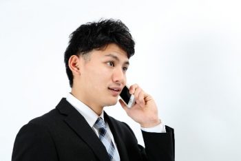 20代で年収1000万円の男性が携帯で電話している様子。